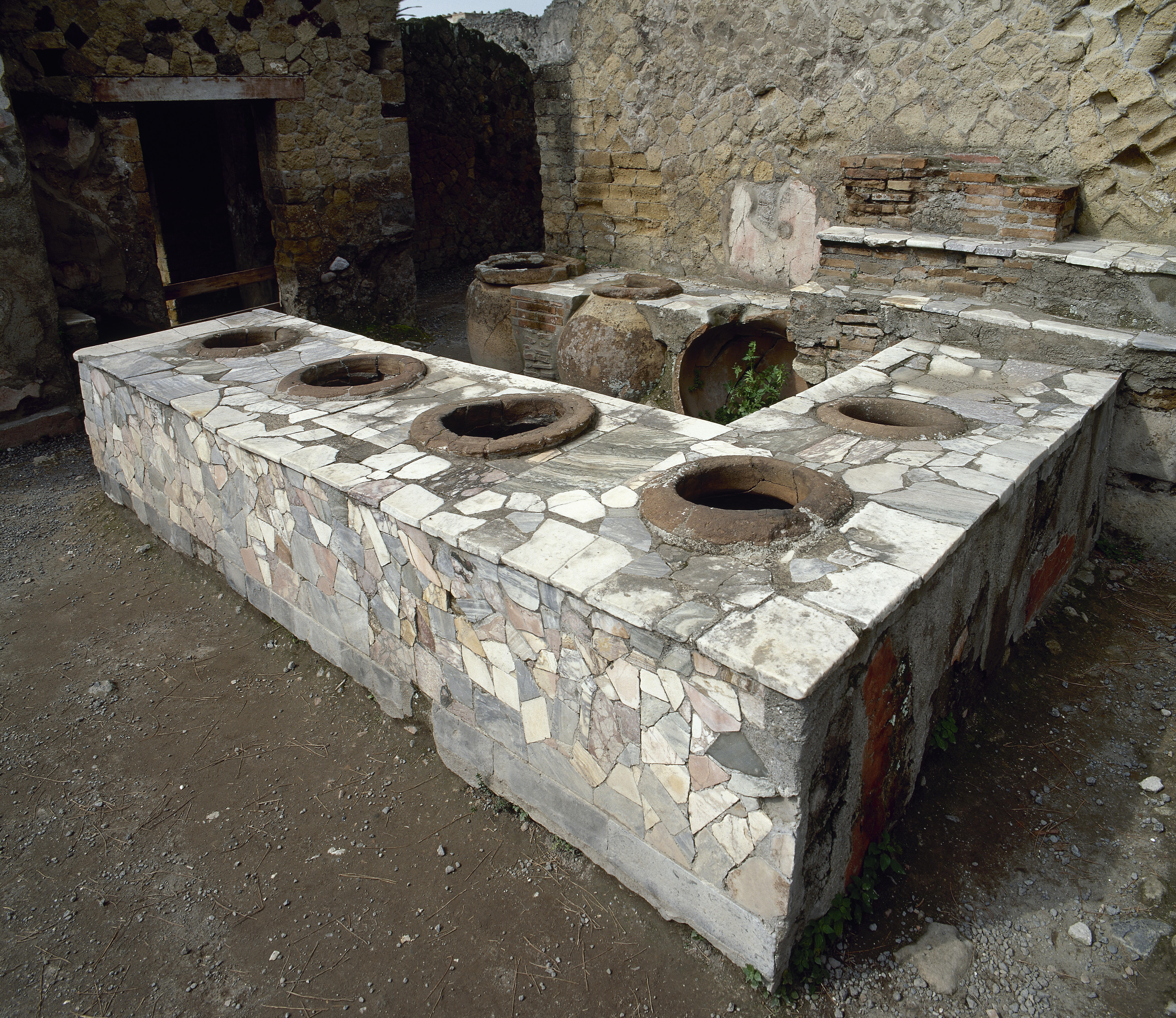 A bar covered in a mosaic pattern of large bits of stone.