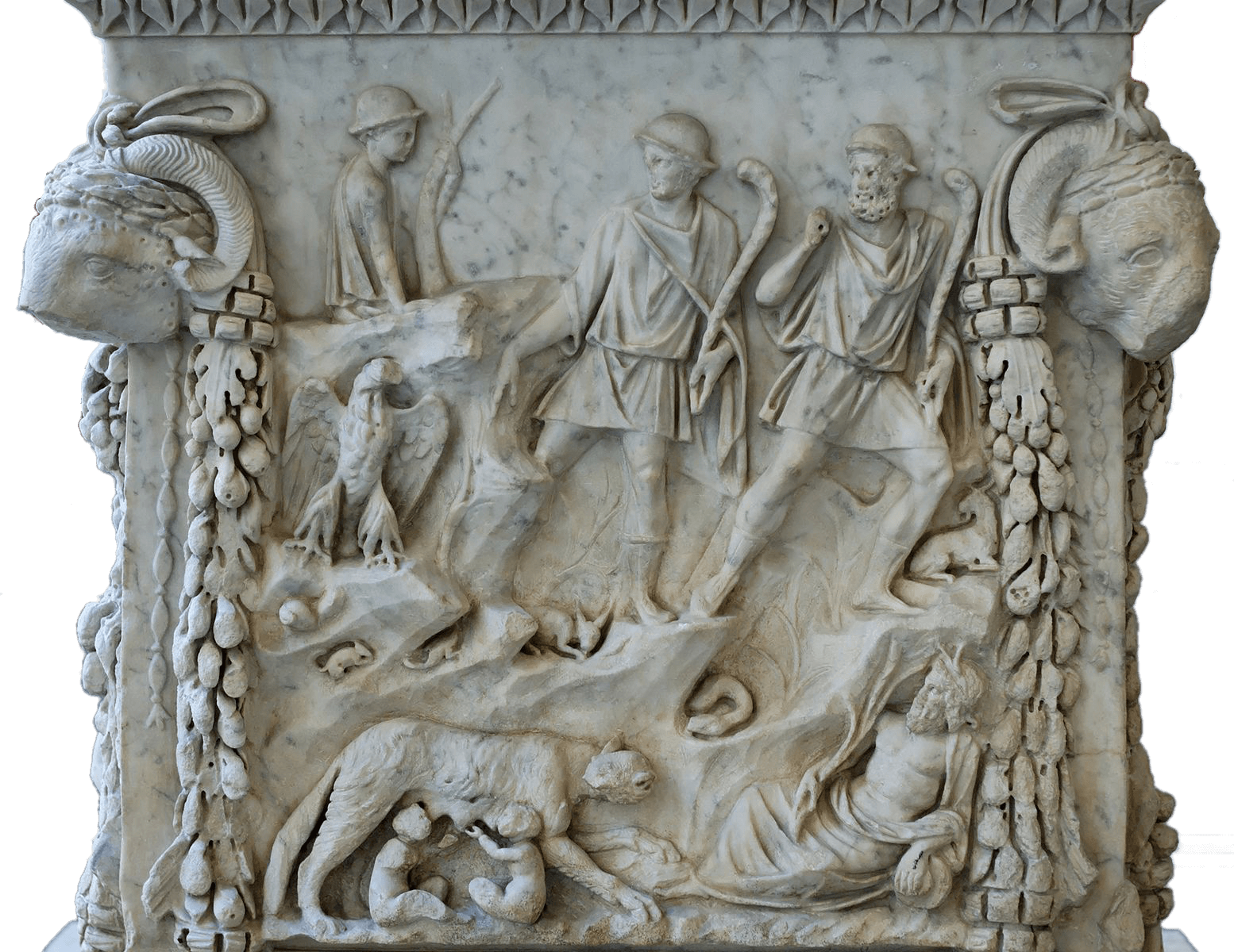 One side of a stone altar. It is intricately carved. At the bottom left a wolf suckles two young children in a cave. On the bottom right an old man with a beard reclines. Above, an eagle sits on the left and two young men wearing caps stand. On the top left a shepherd boy sits with a staff. On either side of the image are two ram heads and garlands of vines.