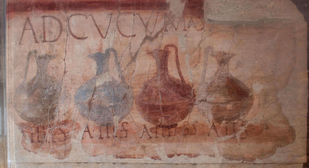 A wall painting with four jugs with handles in a line.