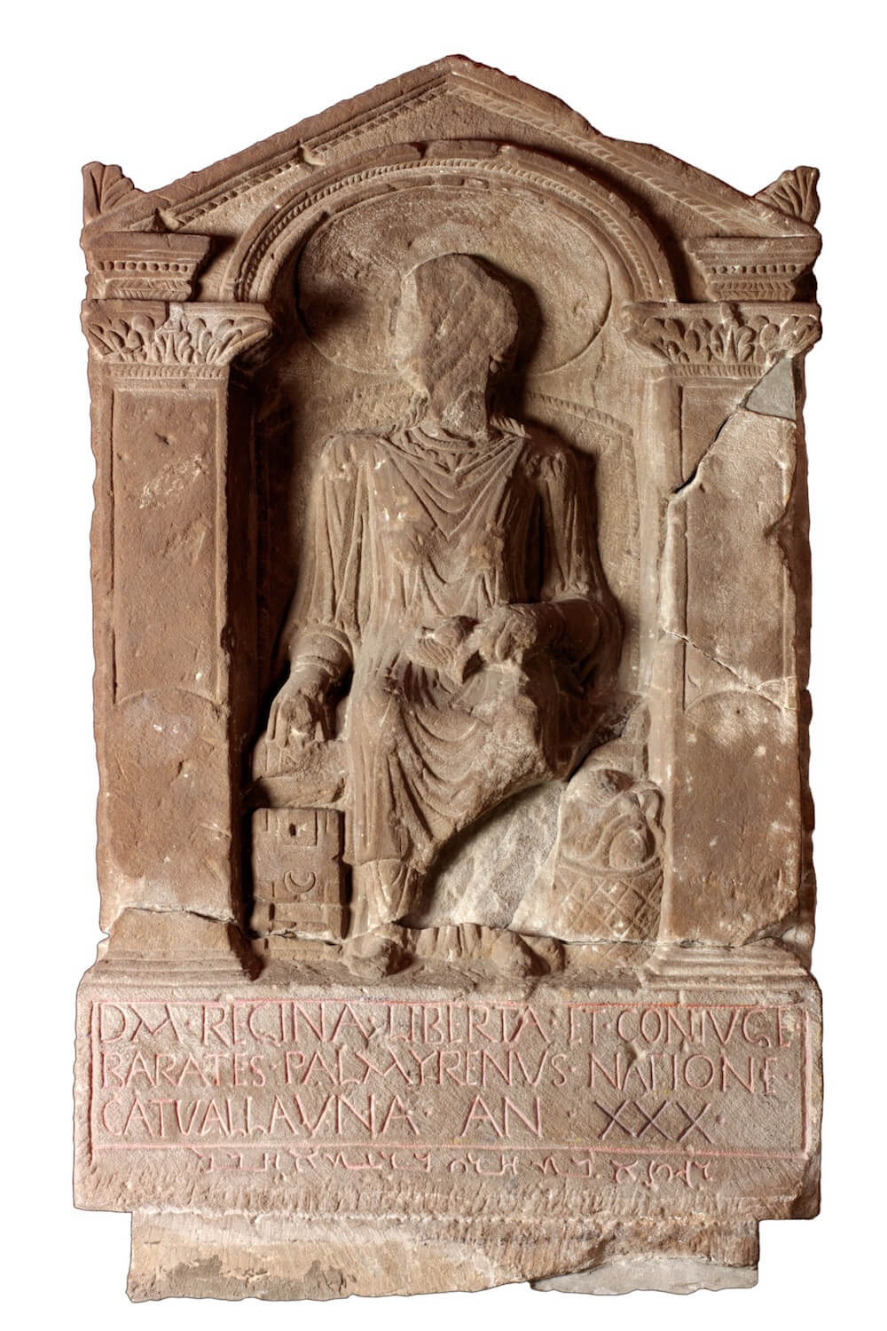 A tombstone with a triangular top. In the centre is a very worn stone carving of a woman standing. Below is carved text.