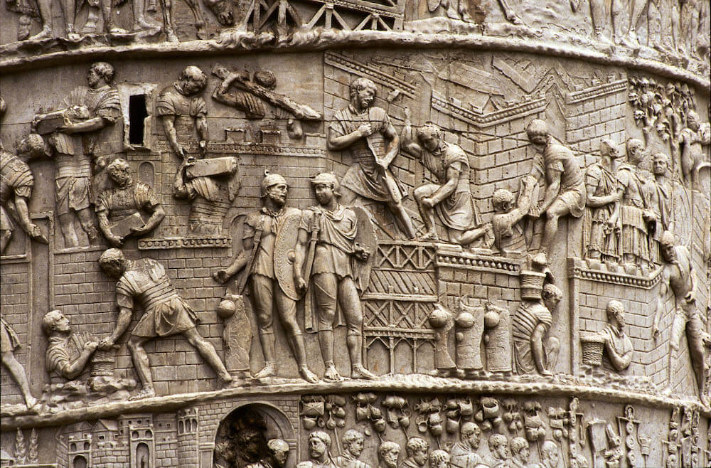 A section of a stone carving showing soldiers building walls.