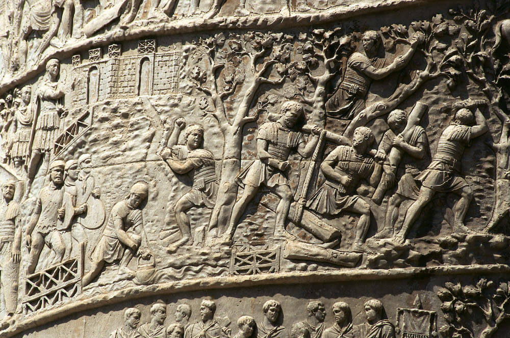 A section of a stone carving showing soldiers cutting down trees.