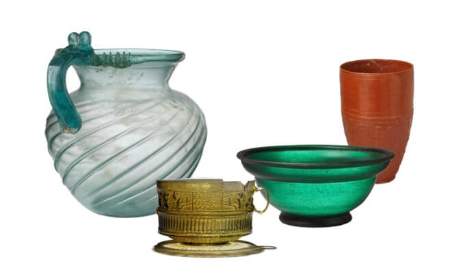 A set of four cups, three made of glass and one of terracotta. They are remarkably intact.