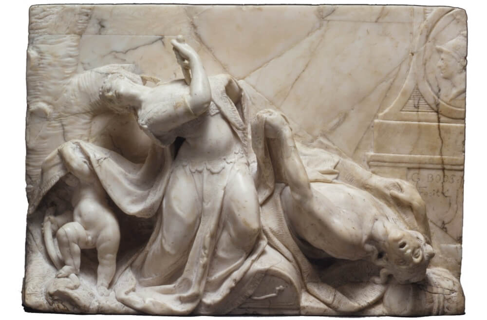 A stone carving showing a woman with a knife and a man lying next to her.