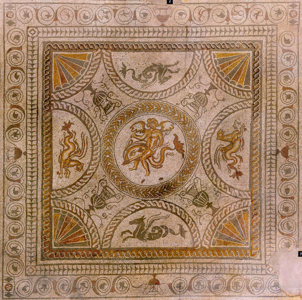 An ornate mosaic depicting sea-monsters, half horse and half serpent, vases, and a divine figure riding a dolphin in the centre.