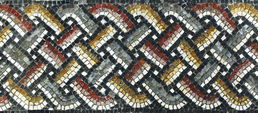 A pattern from a mosaic which looks like a completed plait with red, blue, and yellow strands.