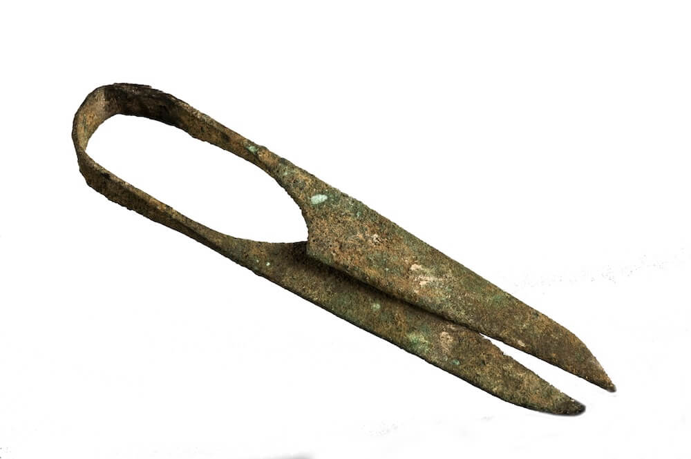 A pair of metal shears. They have two blades joined by a curved handle.