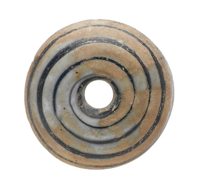 A ring-shaped piece of glass with a spiral of colour.