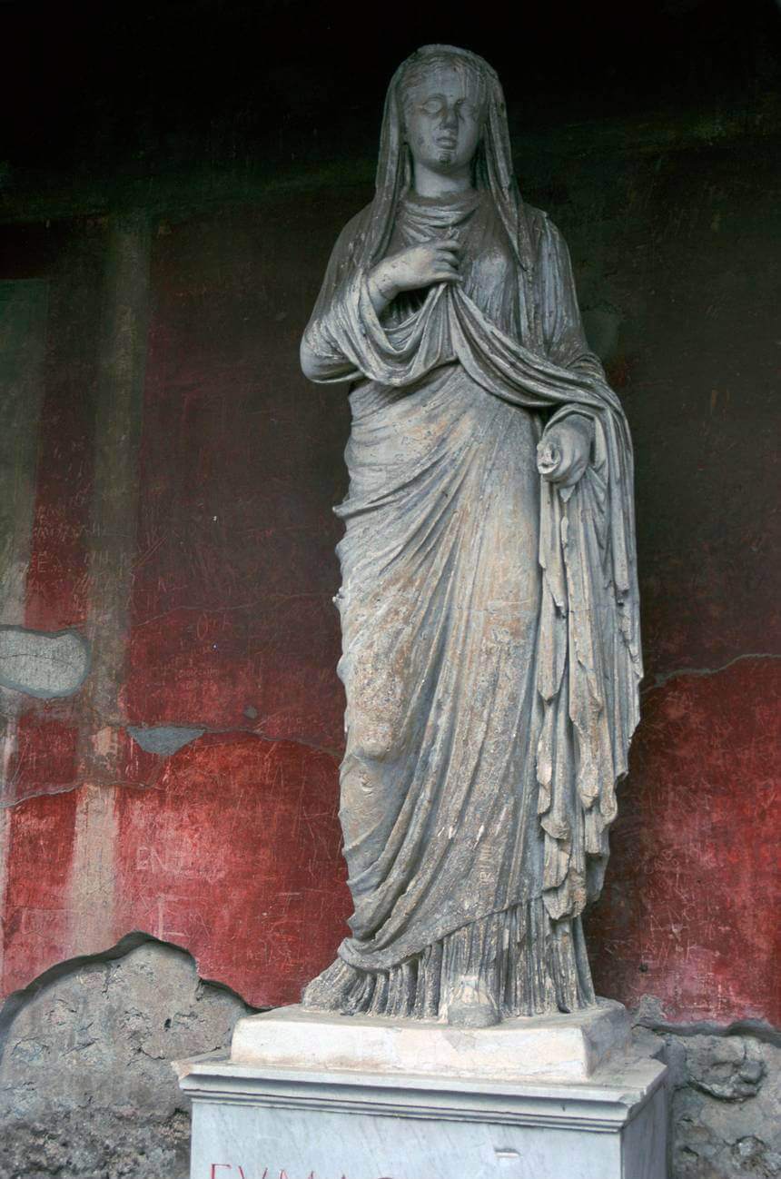 A statue of a woman wearing a long flowing garment and a veil.