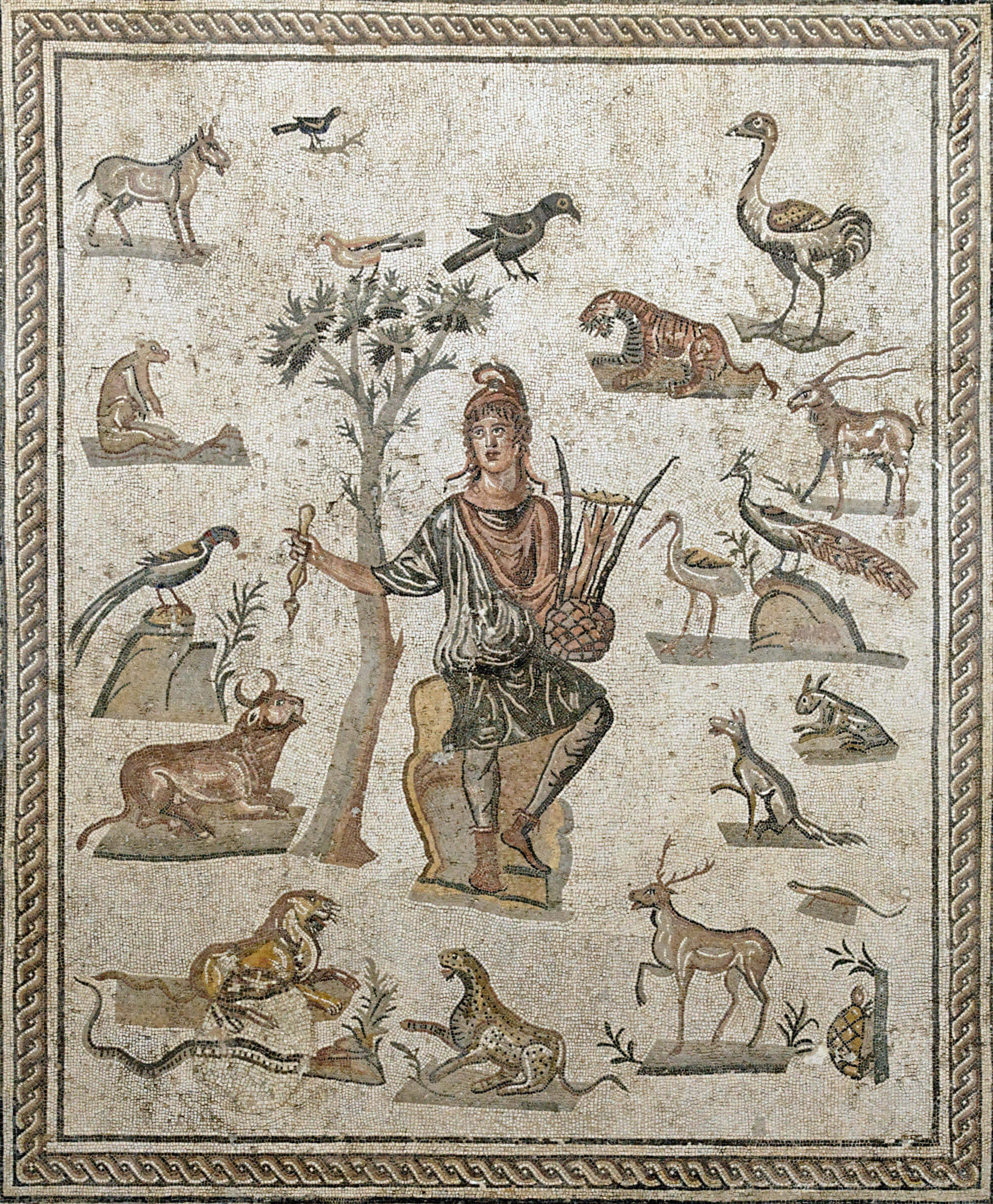 A mosaic showing a man in a tunic, trousers and cloak wearing a pointed hat sitting on a stone holding a stringed lyre (musical instrument). Around him different animals are sitting and looking at him. They include a tiger, a stag, a tortoise, and many others