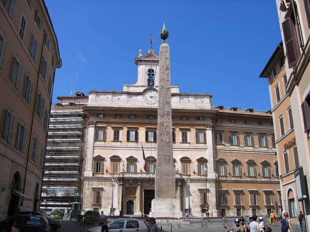 A very tall monument with hieroglyphs up the side. On top is a circular metal ball with a spike.