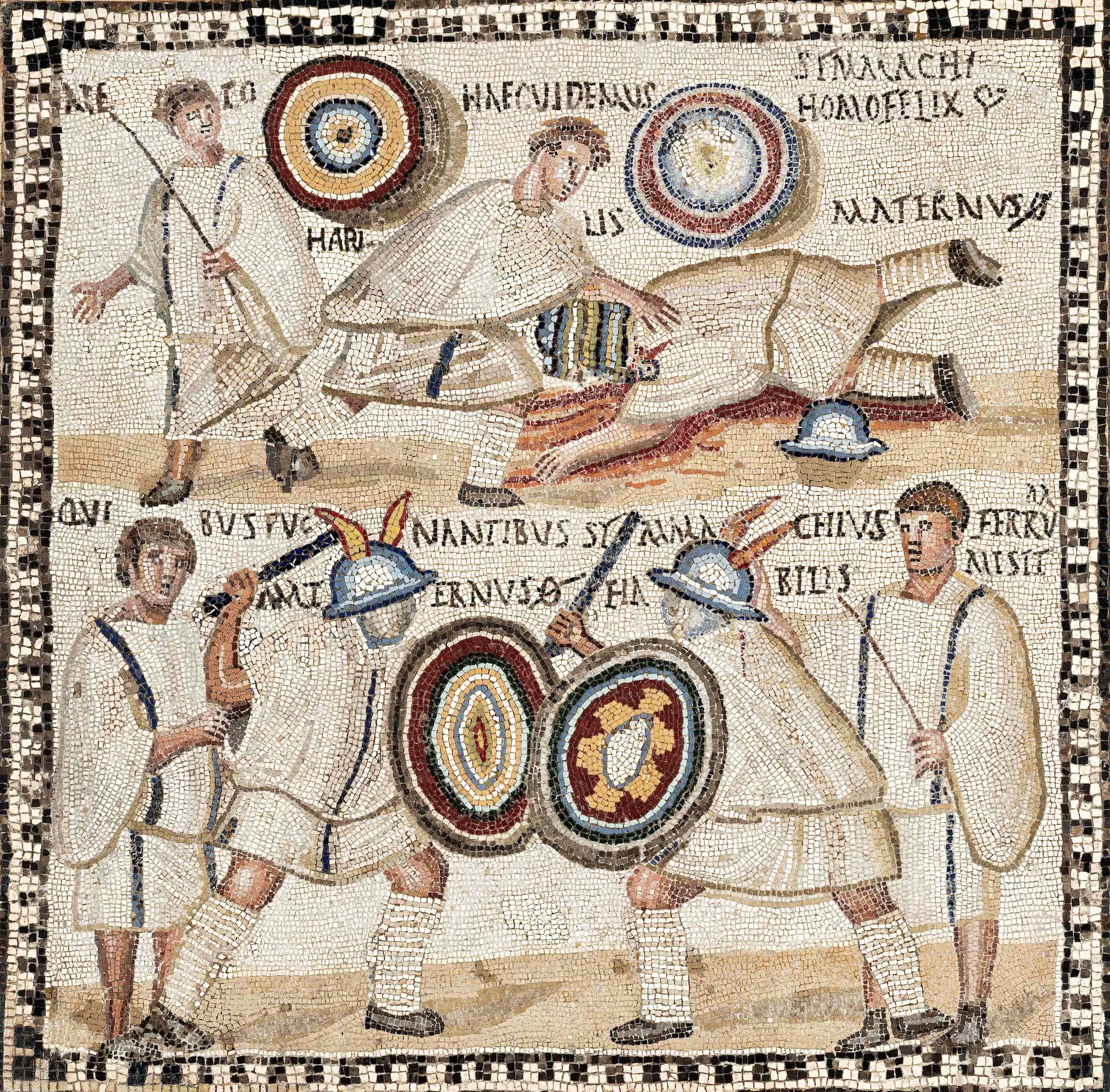 A mosaic showing a gladiatorial fight. On the bottom frame two gladiators with colourful shields fight. On either side of them stands a man in a tunic. In the upper frame one gladiator has fallen and there is blood on the sand.
