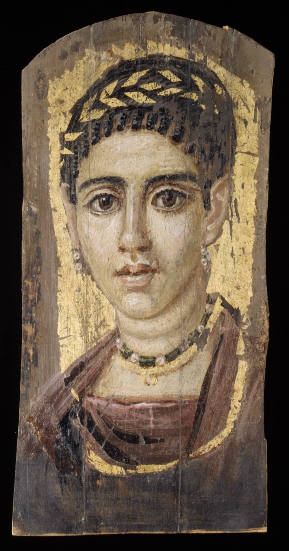 A painting of a woman. She has large eyes and dark eyebrows and a gold band shaped like leaves around the top of her head.