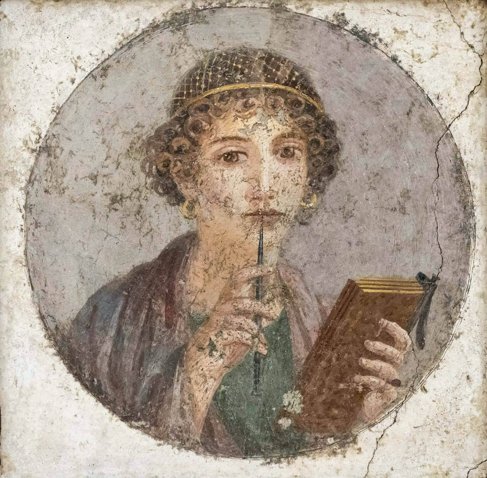 A painting in a circular frame showing a woman holding a writing tablet in her left hand and a stylus in her right.