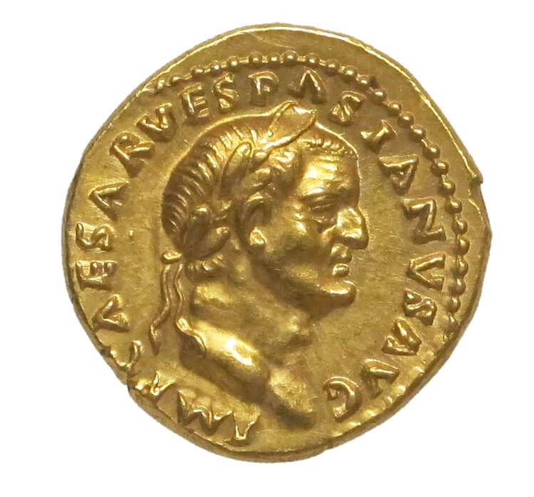 A gold coin with the profile of a man with a crown around his head.