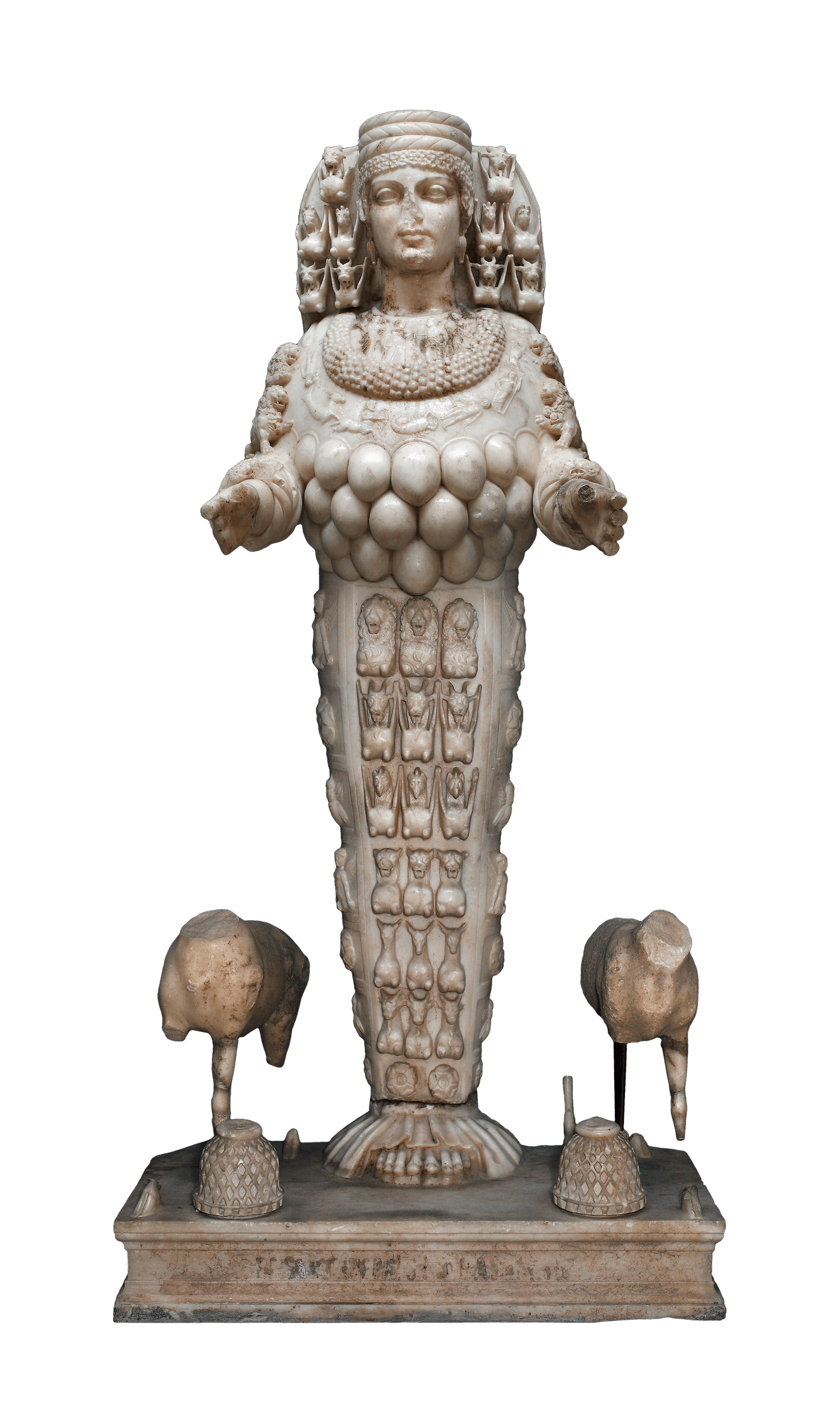 A large statue of a woman. her legs are joined together and decorated in stylized rows of animals. Around her chest hang small ball-like objects and she holds her arms out stiffly in front. She has a decorative headress and more animals are lined either side of her head.