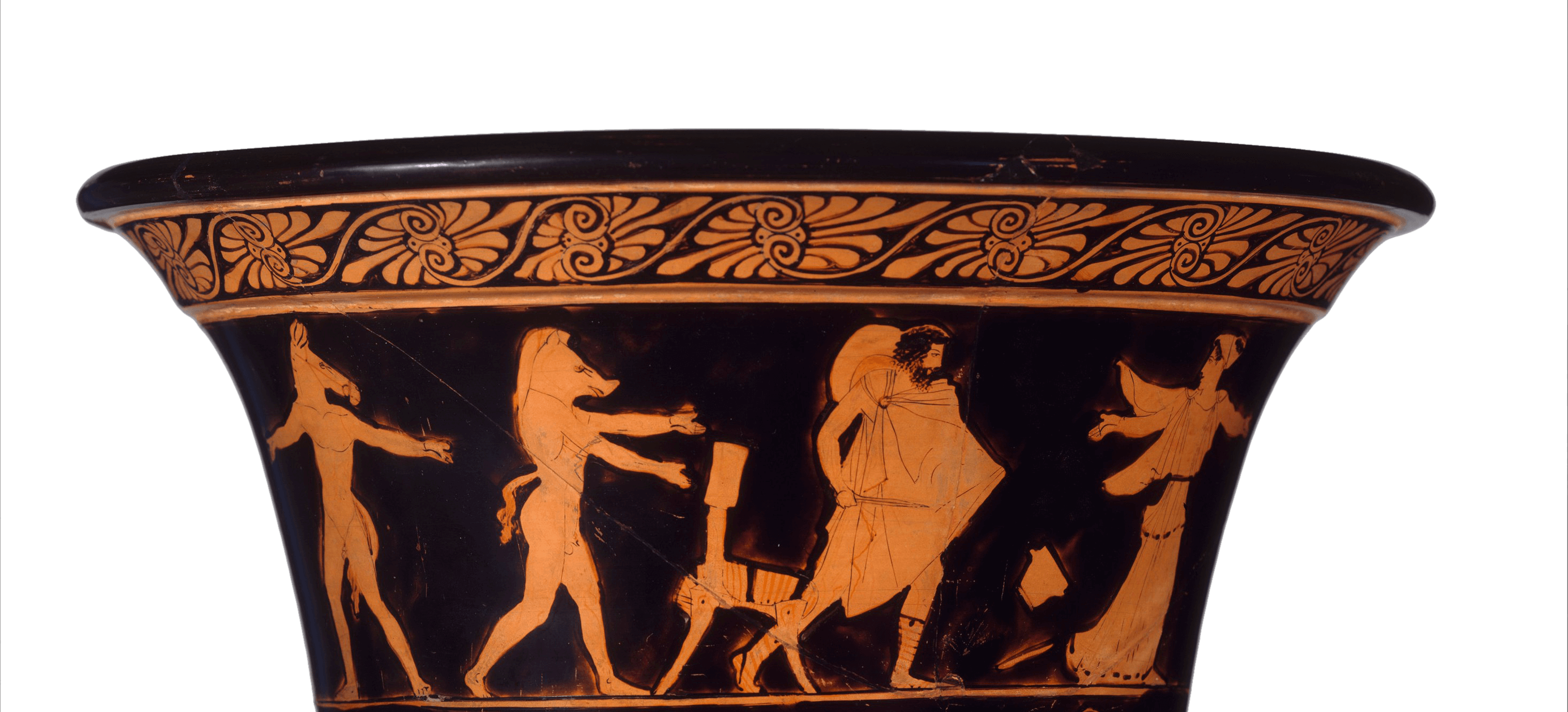 The fluted top of a Greek vase. The figures are picked out in red over a black background. On the left two men with the heads of pigs and with tails are walking. On the right a man with a sword and shield is following a woman in a flowing robe who has thrown down a drinking cup to the floor. Above the figures is a decorative floral pattern.