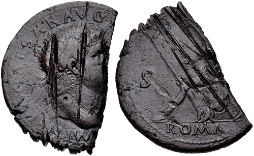 A dark grey coin which has been cut in half. Both sides show signs of scratching and sharp cuts on the surface.