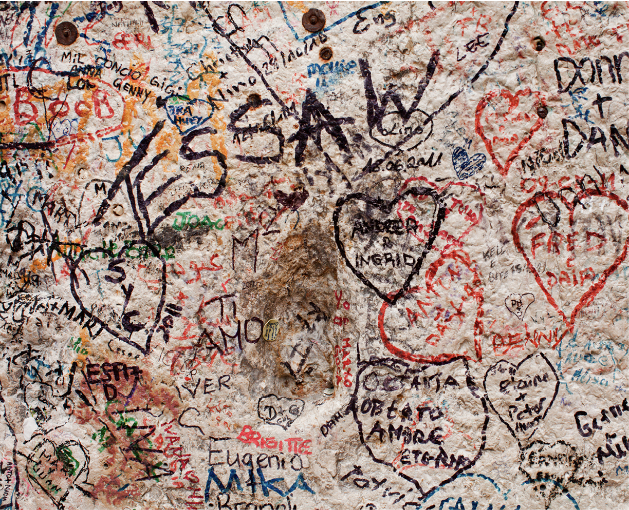 A wall covered in modern graffiti in different colors, layered on top of one another.