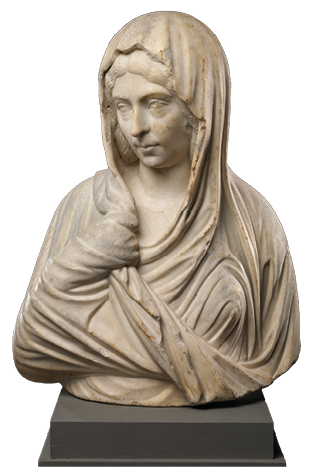 A marble statue of a young woman with a veil wrapped around her shoulders and over her head. She casts her head down to the side.