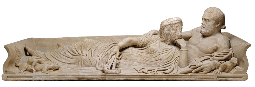 A marble statue showing a couple reclining on a couch. He is topless and she wears a long dress. Her face has no features and is still uncarved.