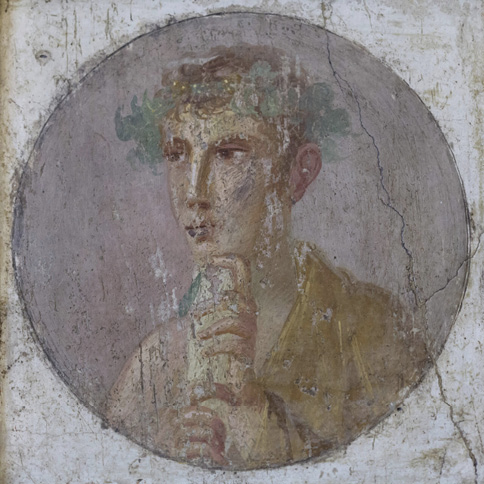 A fresco with a circular portrait showing a young man holding a scroll. He has a crown of leaves around his head.