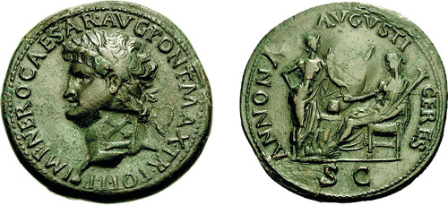 The front and back of a greenish coin. One side shows a head in profile with text in capitals going round the edge. The other side shows a seated figure on the right and a standing figure on the left.