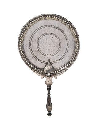 A circular shiny, silver disc with concentric circles engraved on the surface. Around the edge is a simple pattern and the bottom has a thin handle.