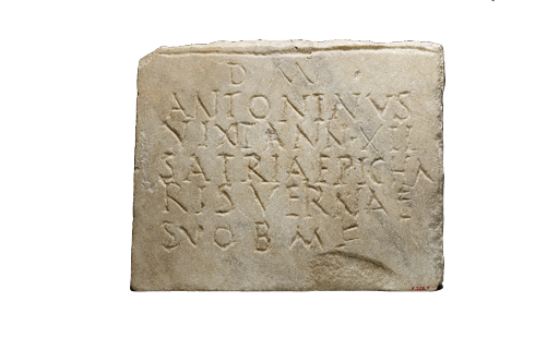 A slab of stone that has been crudely inscribed with capital letters.