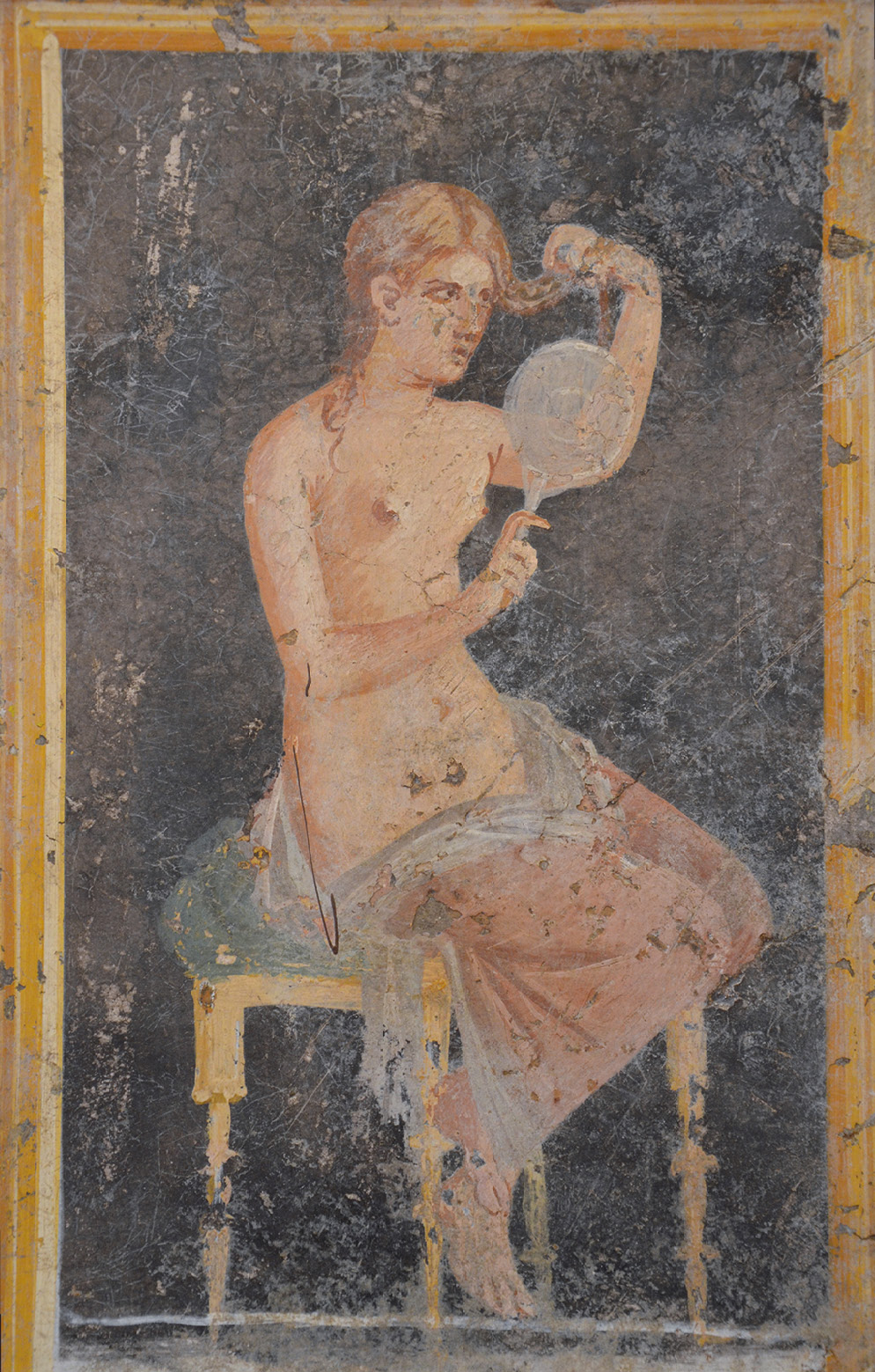 A wall painting showing a woman sitting side on on a stool. In her right hand she holds a hand-held circular mirror. Her left hand holds up a tress of hair. She is nude to the waist and has a garment wrapped around her legs.