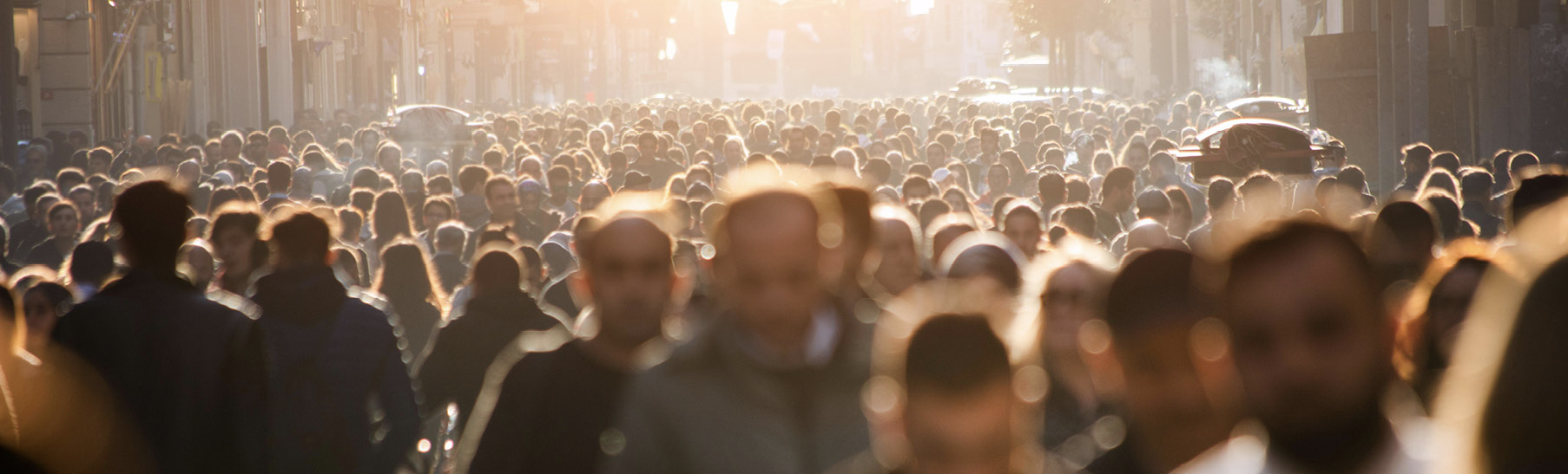 A blurry photo of a crowded street with people passing both directions.