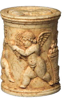 A cylindrical box in a pale yellow color. It is carved with images of winged children.