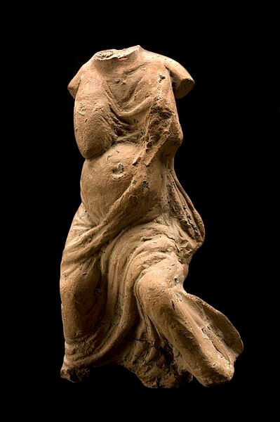 A rough model of a pregant female with a flowing robe. Her head and arms are missing.