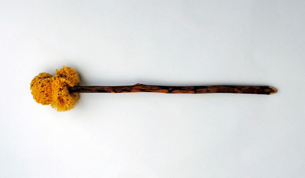 A natural sponge attached to a stick.