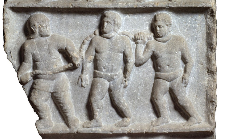 A relief showing three collared slaves.