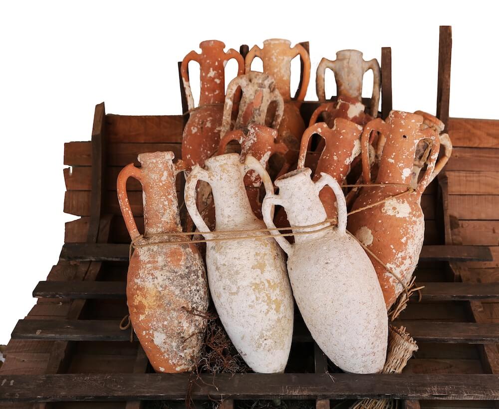 A number of large amphorae on a wooden rack.