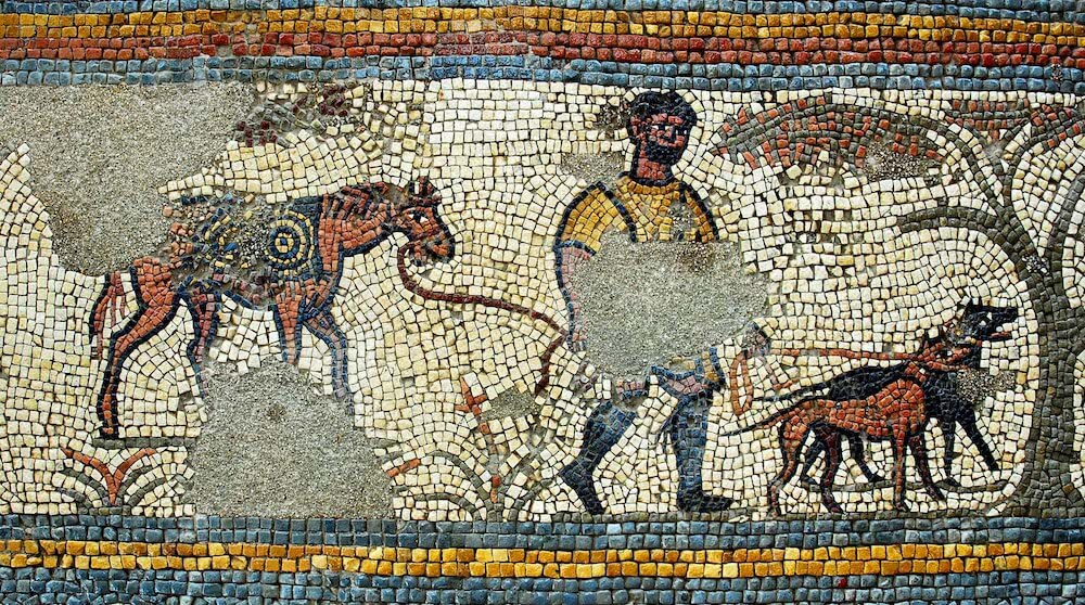 A mosaic showing a man walking with two dogs on leads ahead of him, and leading a horse behind him.