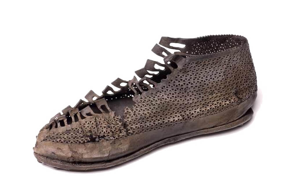 A tongueless shoe with a delicate pattern of equilateral triangles carbed into the brown leather.